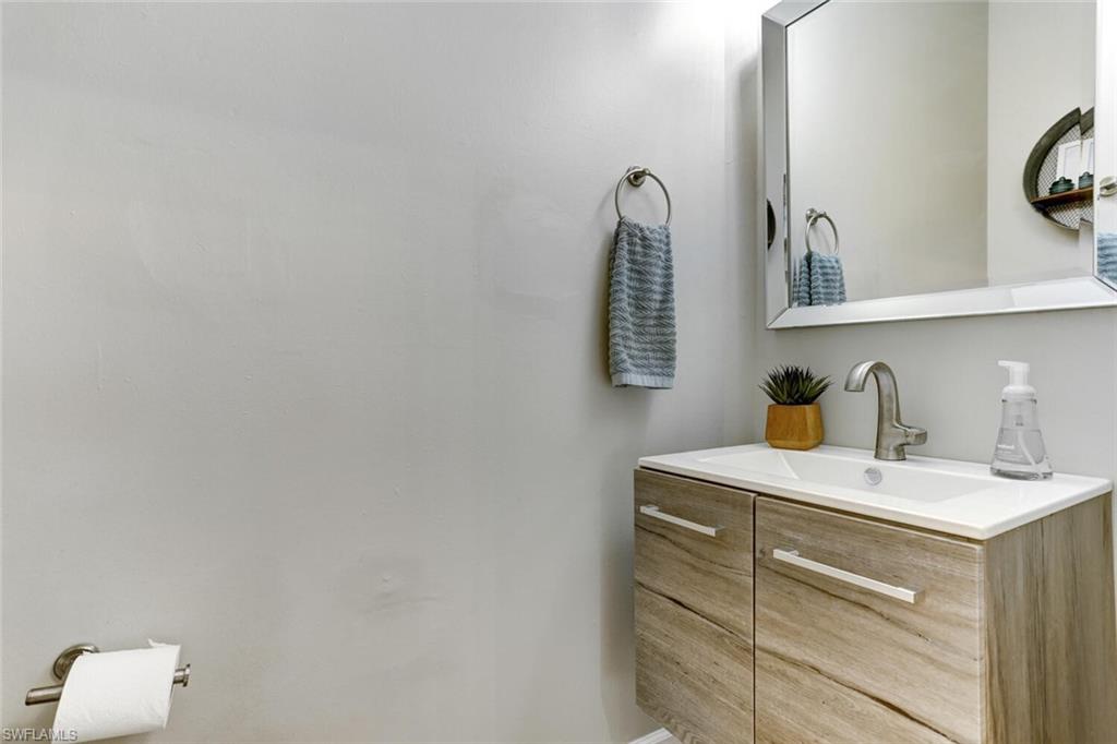 14966 Summit Pl Circle Naples, FL 34119 - Photo 9 of 14 a bathroom with a sink vanity and a mirror