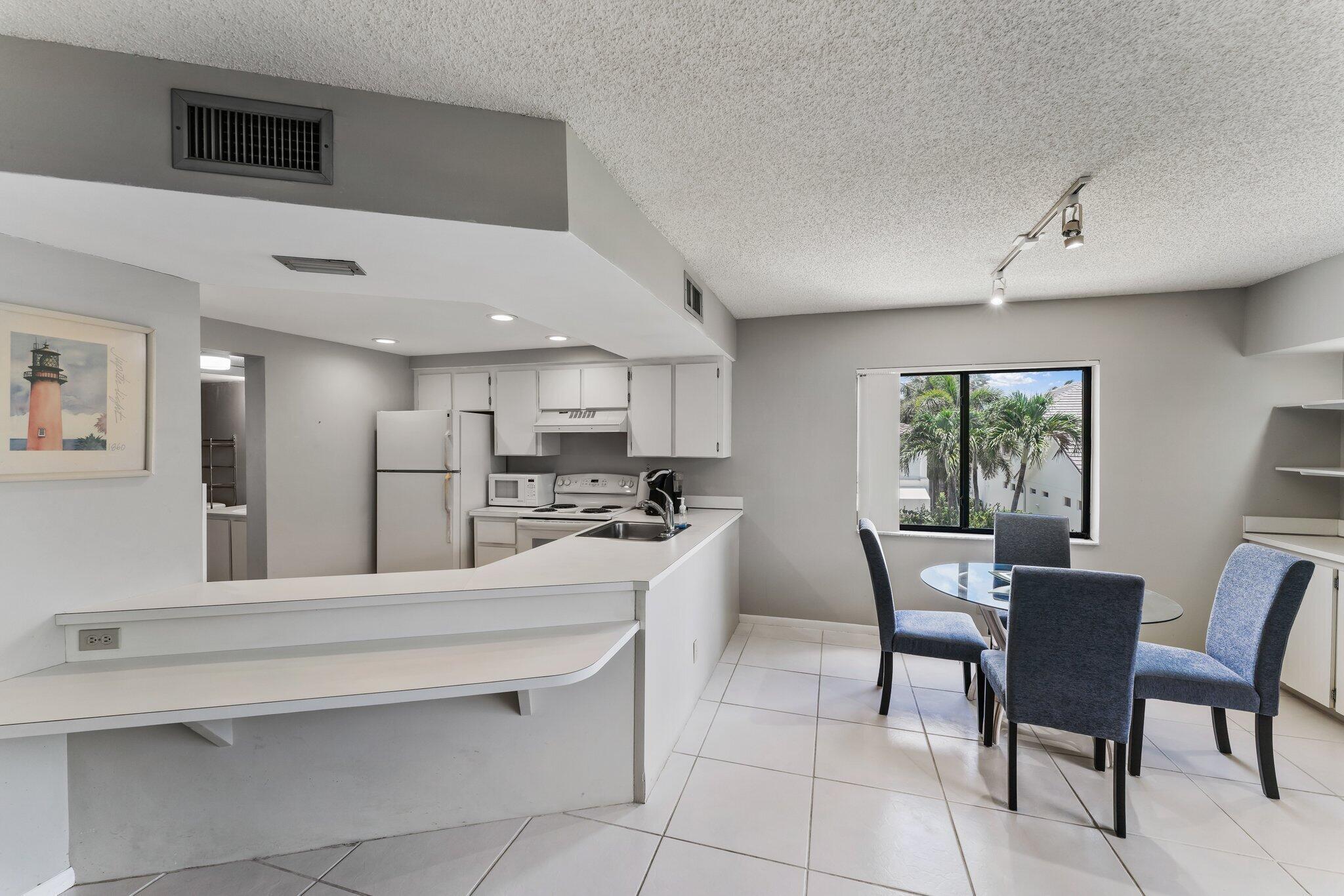 1605 Highway 1, Unit D301 Jupiter, FL 33477 - Photo 17 of 46 a kitchen with stainless steel appliances kitchen island granite countertop a sink and cabinets