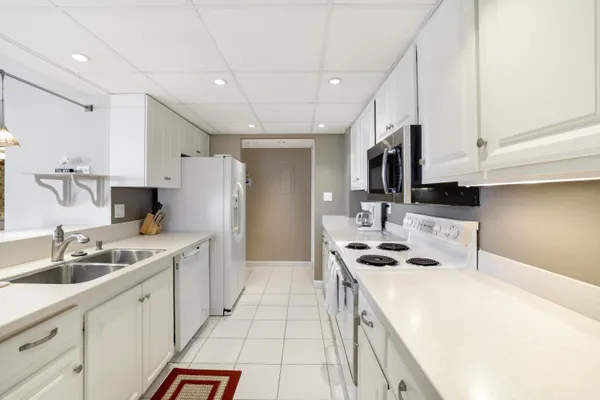 a kitchen with stainless steel appliances a sink stove refrigerator and cabinets