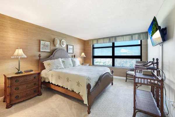 a bedroom with a bed a bookshelf and a flat screen tv