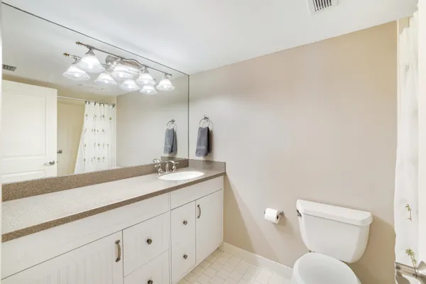 a bathroom with a granite countertop sink mirror and toilet