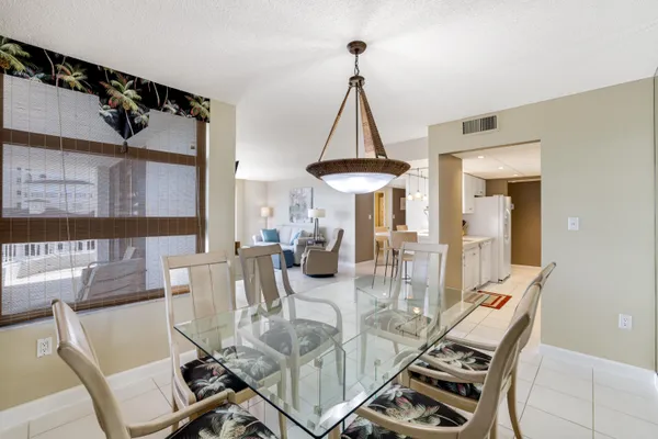a view of a dining room with furniture a chandelier and wooden floor