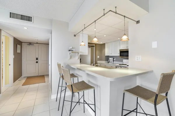 a kitchen with a sink and chairs