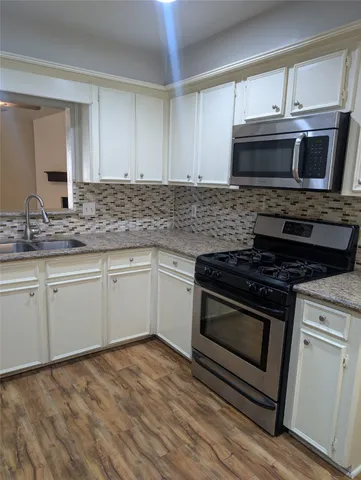 a kitchen with granite countertop a stove and a sink