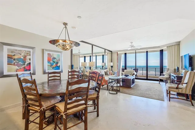 a dining room with furniture a chandelier and wooden floor