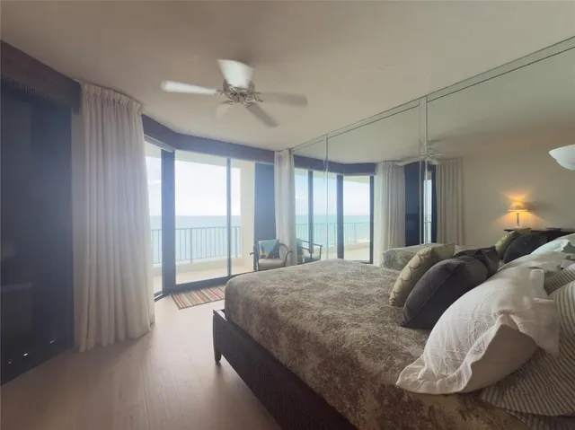 a bedroom with a bed a large window and flat screen tv