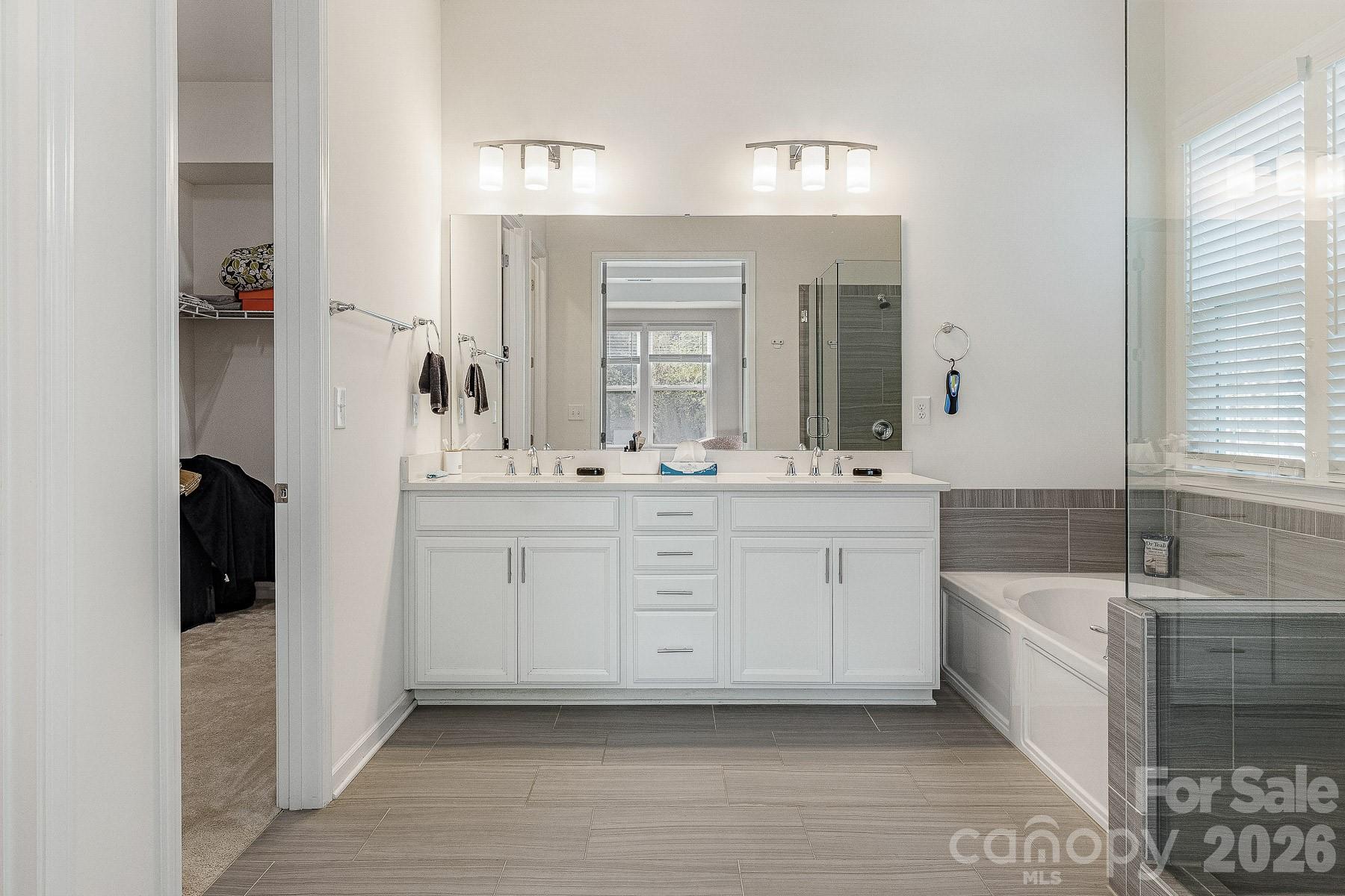 2036 Oliver Terrace Fort Mill, SC 29707 - Photo 28 of 41 a bathroom with a double vanity sink a mirror and a bathtub