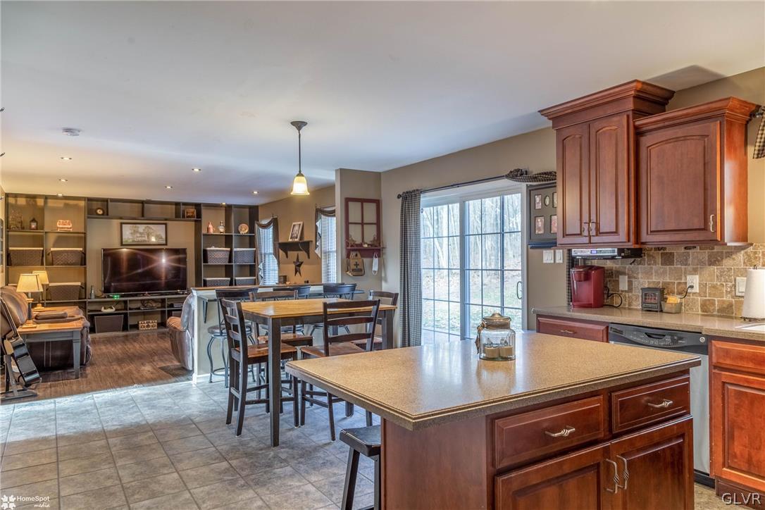 269 Germanville Road Ashland, PA 17921 - Photo 8 of 36 a open kitchen with stainless steel appliances granite countertop a stove a refrigerator a dining table and chairs with wooden floor