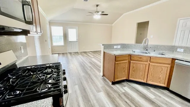 a kitchen with stainless steel appliances granite countertop a sink stove and microwave