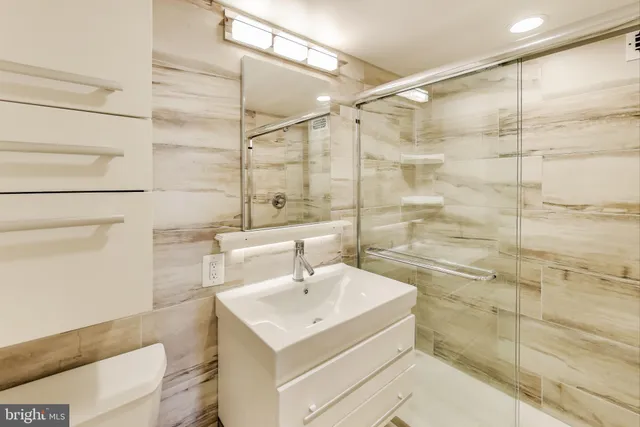a bathroom with a sink shower and a mirror