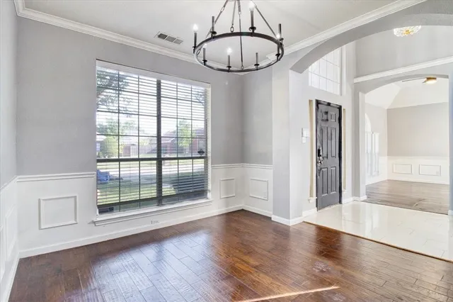 a view of an empty room with wooden floor fireplace and a window