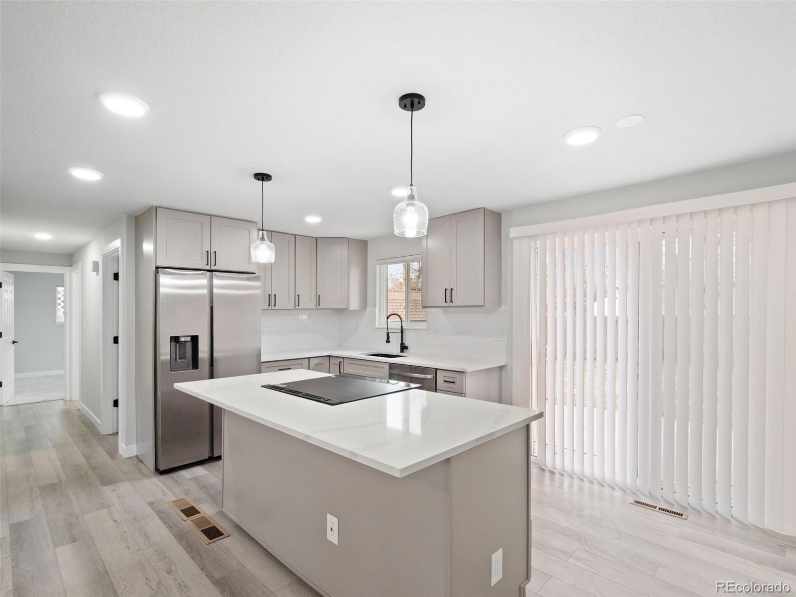 1035 6th Street Berthoud, CO 80513 - Photo 13 of 30 a kitchen with kitchen island a sink stainless steel appliances and cabinets