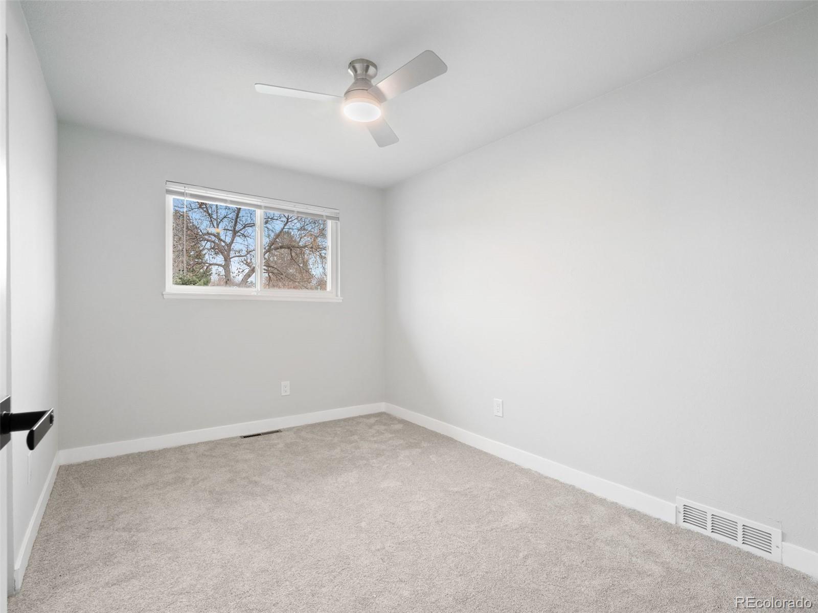 1035 6th Street Berthoud, CO 80513 - Photo 16 of 30 an empty room with a chandelier fan
