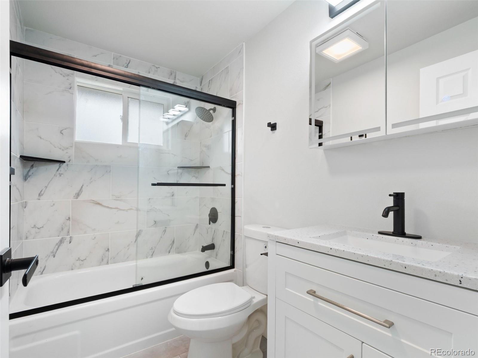 1035 6th Street Berthoud, CO 80513 - Photo 20 of 30 a bathroom with a granite countertop sink toilet and shower