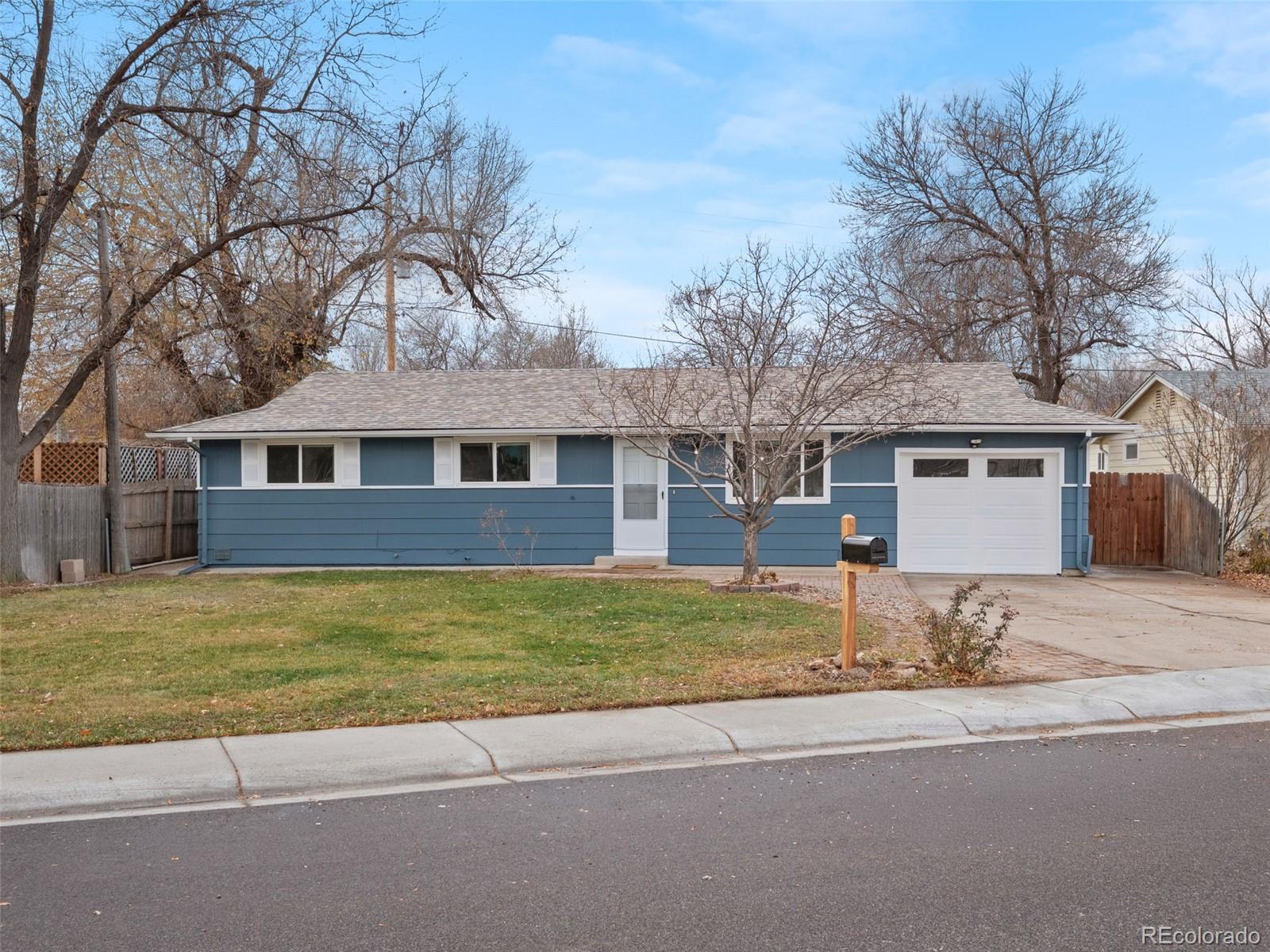 1035 6th Street Berthoud, CO 80513 - Photo 2 of 30 a front view of a house with a garden and trees