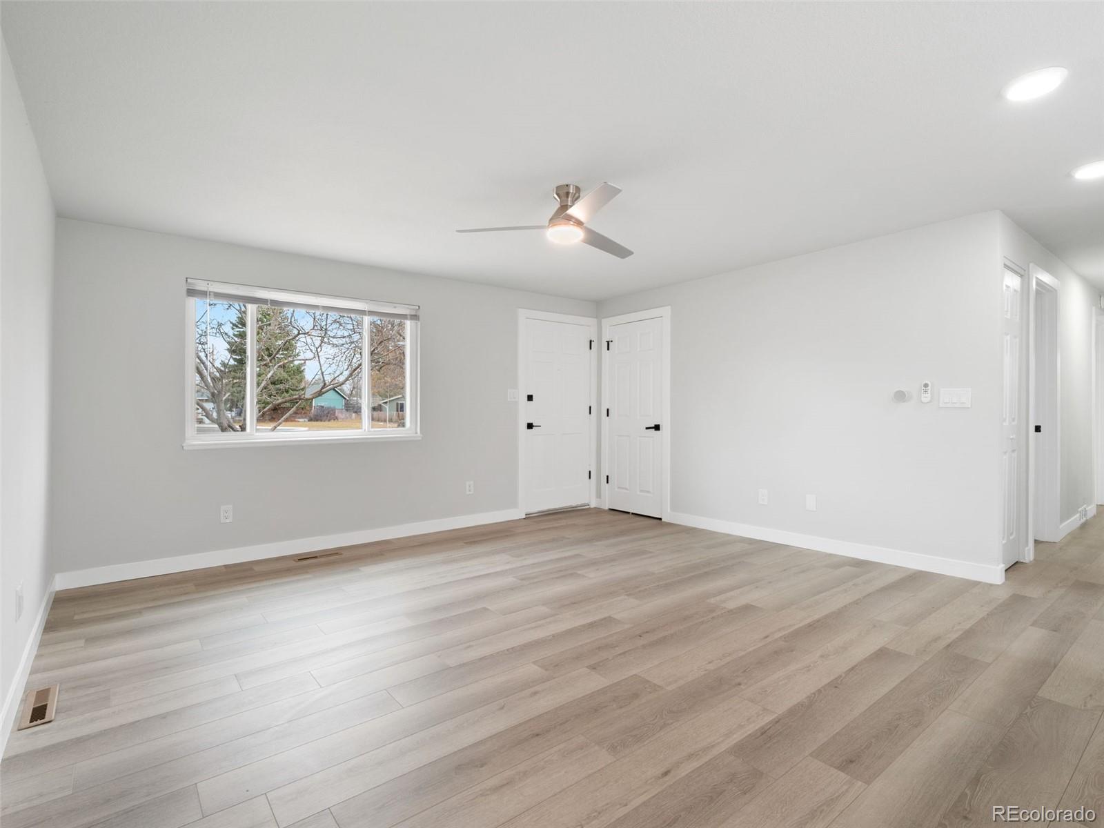 1035 6th Street Berthoud, CO 80513 - Photo 7 of 30 a view of an empty room with wooden floor and a window