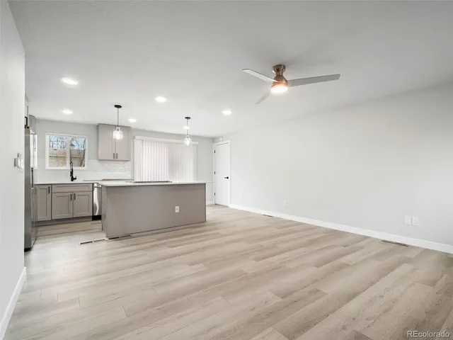 a view of kitchen with kitchen island wooden floor center island and appliances