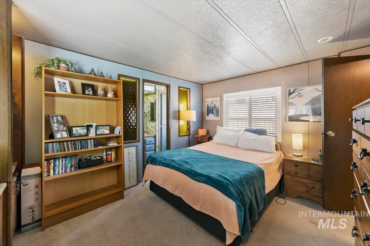 915 South Curtis Road, Unit 68 Boise City, ID 83705 - Photo 9 of 20 Carpeted flooring, built-in shelving unit, and a window with blinds