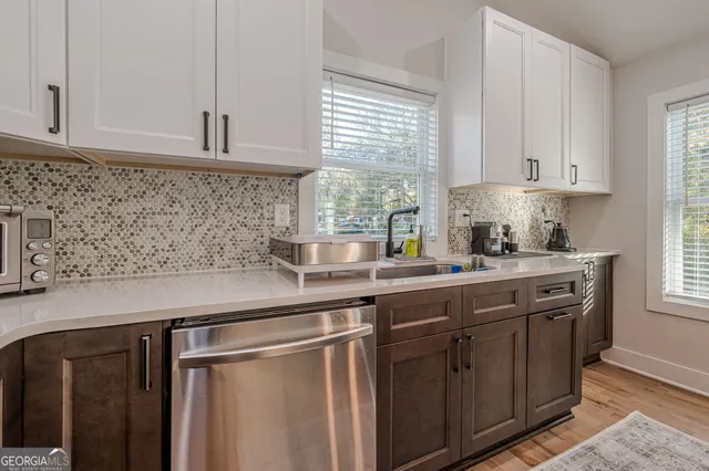 a kitchen with stainless steel appliances granite countertop a sink a stove and a microwave