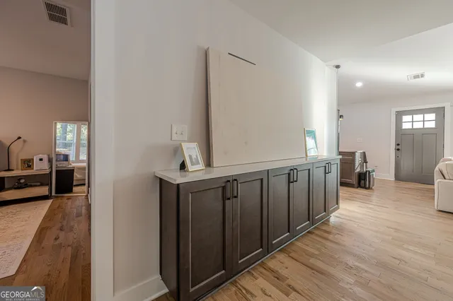 a view of a hallway with wooden floor and furniture