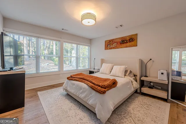 a spacious bedroom with a large bed and a chandelier