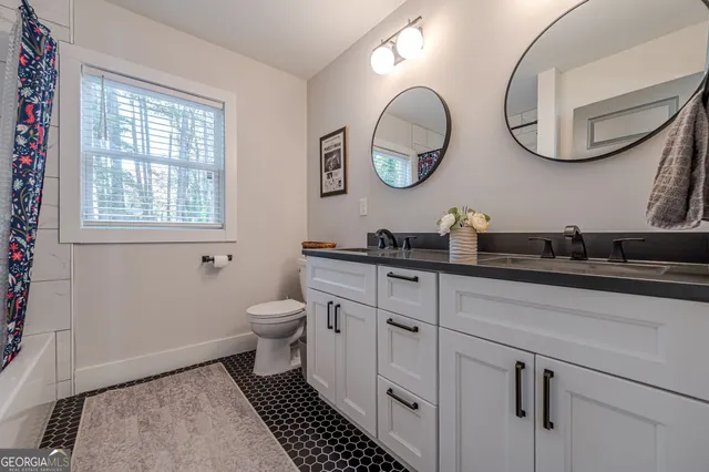 a bathroom with a toilet a sink and mirror