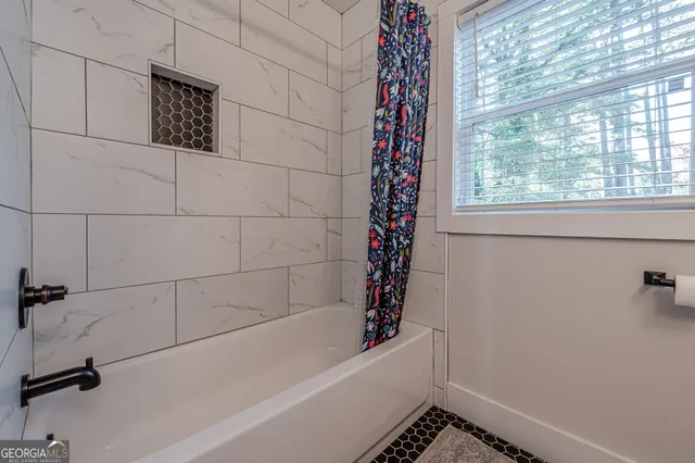a bathroom with a bathtub and shower