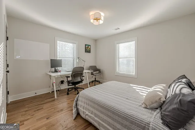 a bedroom with a bed and a table in it with window
