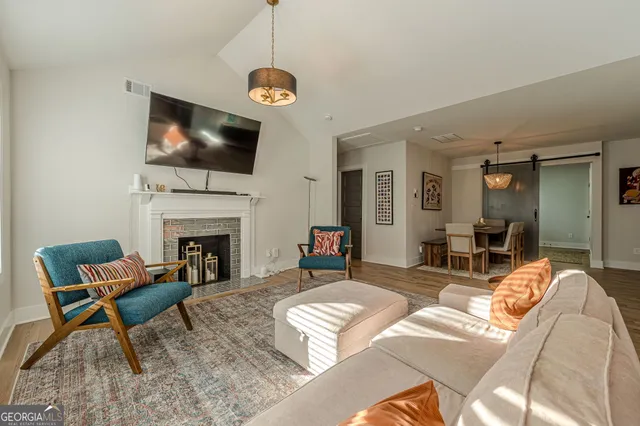 a living room with furniture a flat screen tv and a fireplace