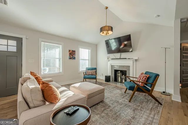 a living room with furniture a fireplace and a flat screen tv