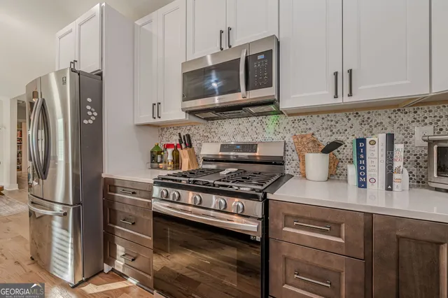 a kitchen with stainless steel appliances granite countertop a refrigerator stove and microwave