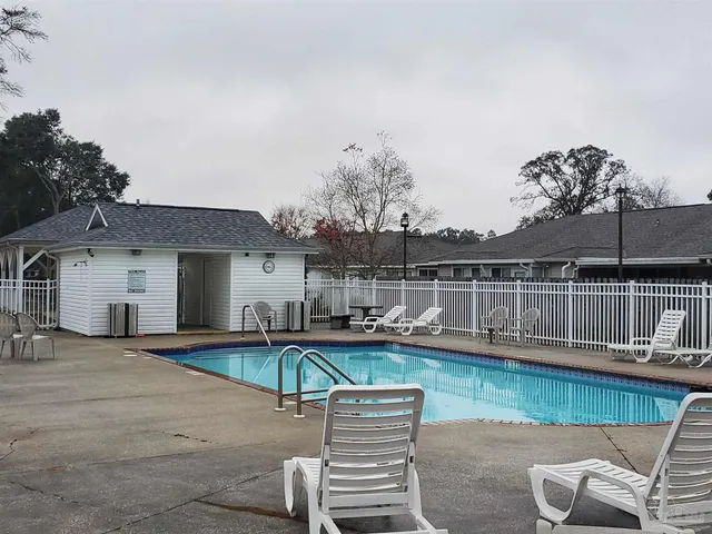 a view of a patio with table and chairs potted plants and large tree