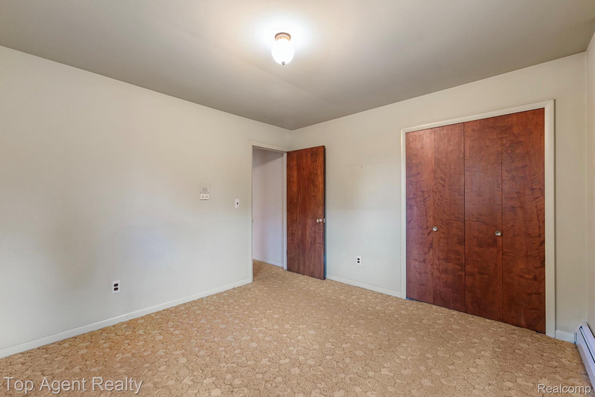 8269 Currie Road Northville, MI 48168 - Photo 33 of 80 Wall-to-wall patterned carpeting, neutral wall paint, built-in bi-fold closet with wood-finish doors, and a ceiling-mounted light fixture