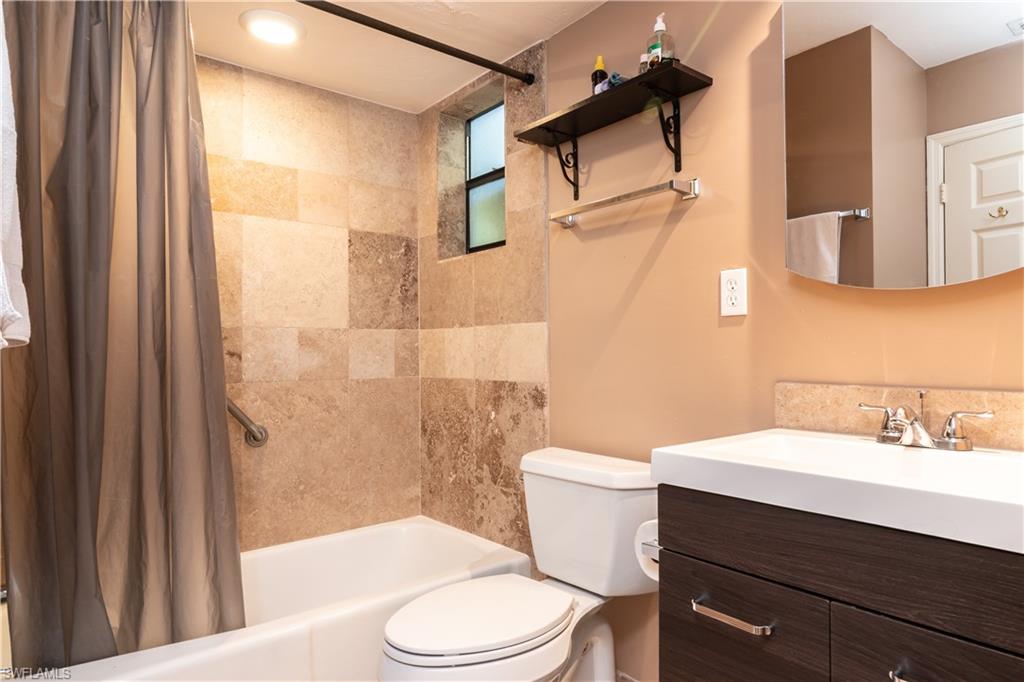 1295 Solana Road, Unit C5 Naples, FL 34103 - Photo 9 of 13 a bathroom with a sink a toilet a mirror and shower