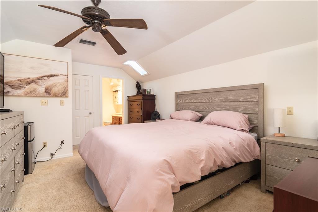 1295 Solana Road, Unit C5 Naples, FL 34103 - Photo 10 of 13 a bedroom with a bed and a chandelier