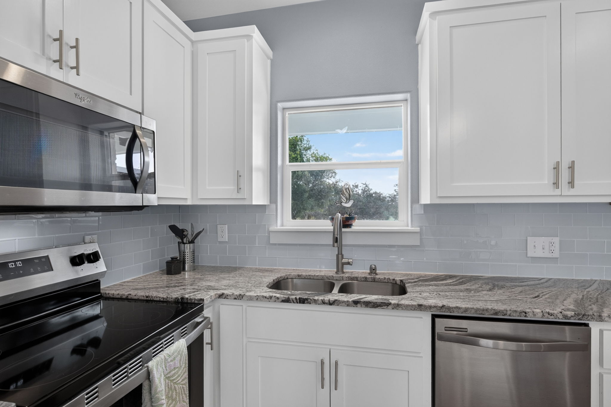 207 Deer Ridge Drive Burnet, TX 78611 - Photo 20 of 36 White cabinetry, sleek countertops, and a modern appliance suite define this well-appointed kitchen.