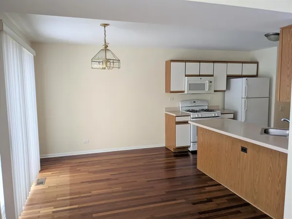a kitchen with a wooden floor and a stove top oven
