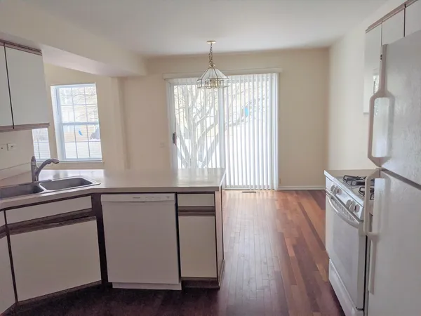 a kitchen with granite countertop a stove a sink and wooden floor