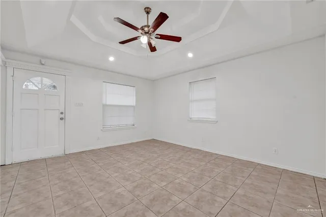 an empty room with a ceiling fan and a window