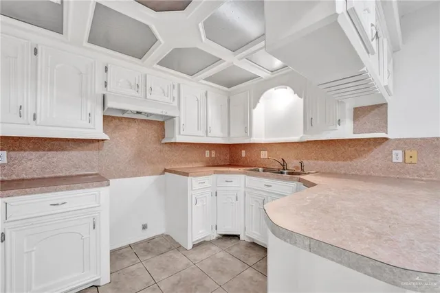 a kitchen with granite countertop white cabinets and white appliances