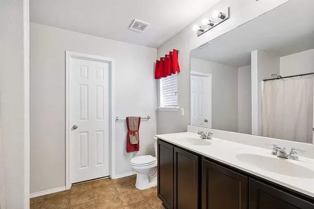 a bathroom with a sink vanity mirror and toilet