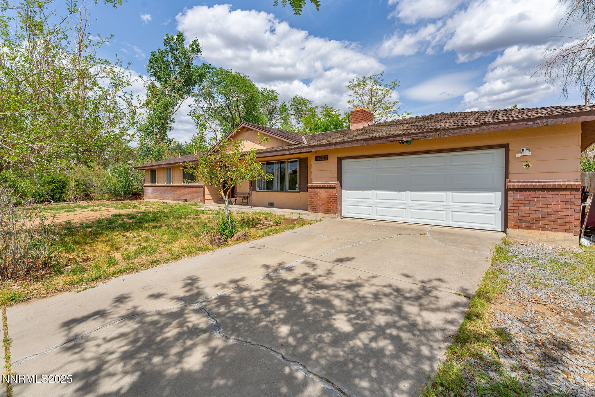 14590 Rancheros Drive Reno, NV 89521 - Photo 2 of 31 a front view of a house with a yard and garage