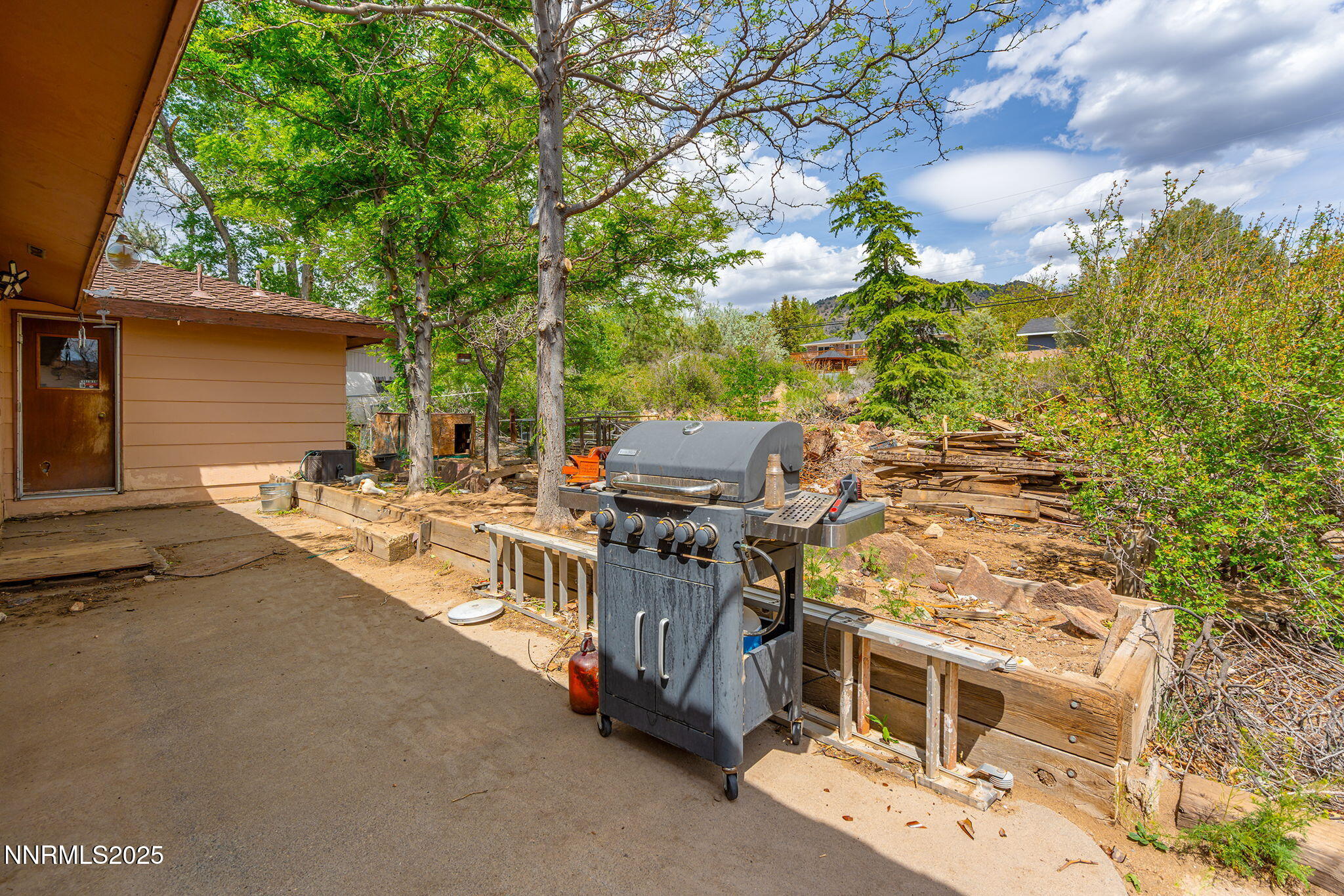 14590 Rancheros Drive Reno, NV 89521 - Photo 23 of 31 a view of a patio with table and chairs with wooden fence and plants
