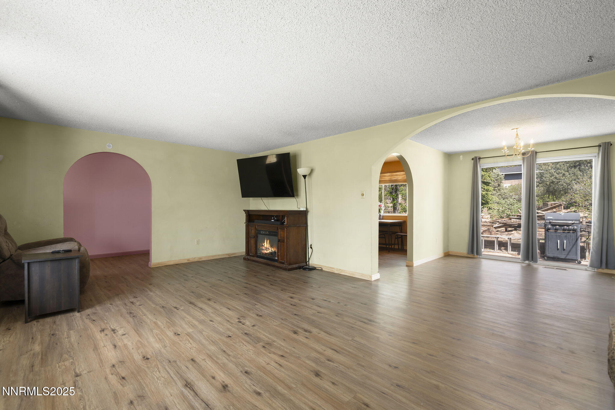 14590 Rancheros Drive Reno, NV 89521 - Photo 9 of 31 a view of an empty room with wooden floor and a fireplace