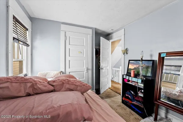 a bedroom with a bed furniture and a flat tv screen