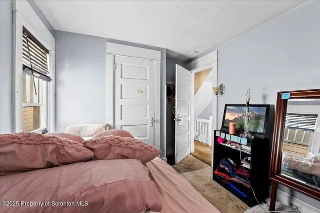 a bedroom with a bed furniture and a flat tv screen