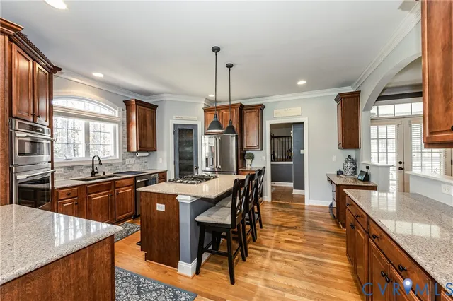 a kitchen with granite countertop a stove a sink a dining table and chairs