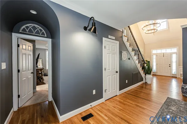 a view of a hallway with wooden floor and stairs
