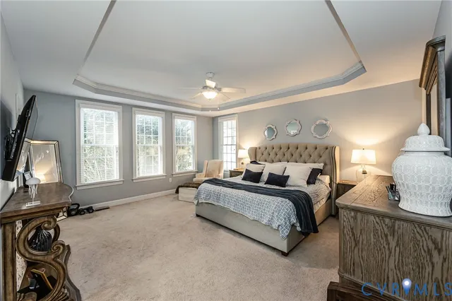 a spacious bedroom with a bed a couch and large windows