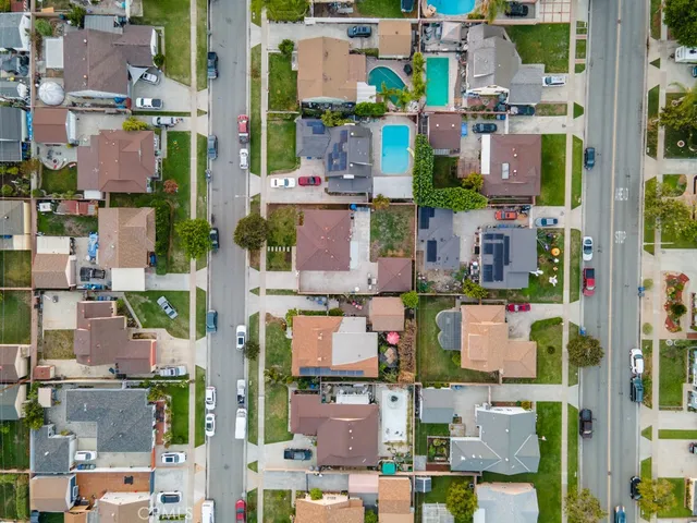 an aerial view of residential houses with outdoor space and parking